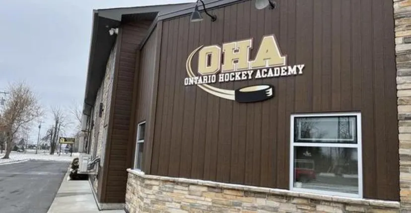 Si vede l'edificio della Ontario Hockey Academy con rivestimento in legno e il logo sulla facciata.