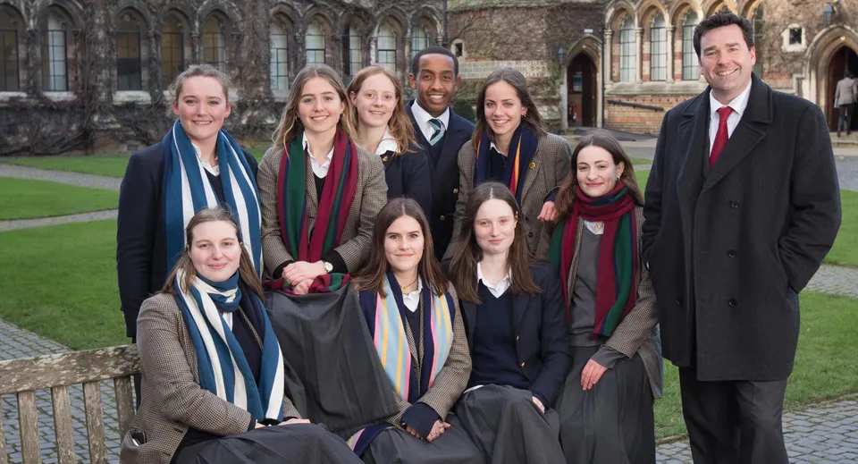 Un gruppo di studenti della Rugby School mette in posa davanti a un edificio storico con elementi gotici.