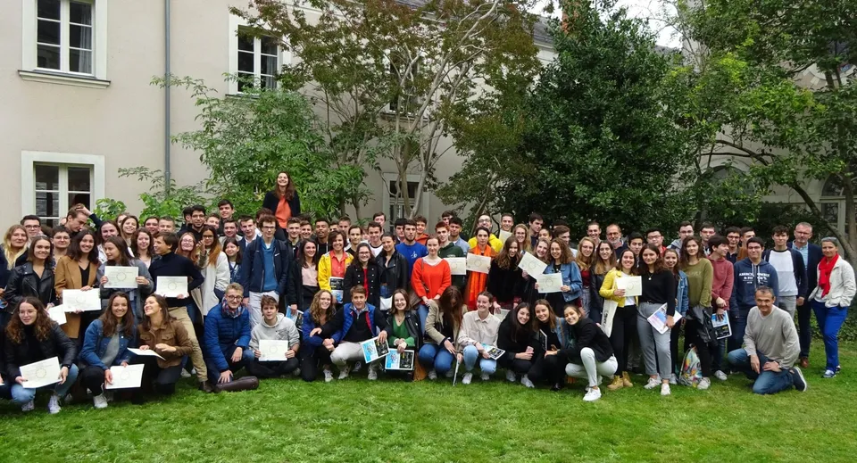 Un gruppo di studenti e studentesse si riunisce sul prato davanti a un edificio della Institution Mongazon.