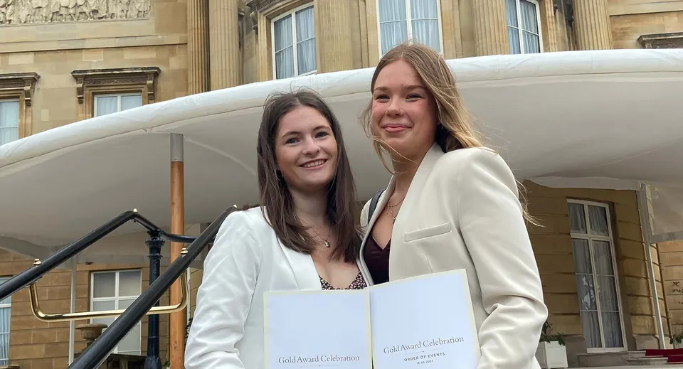Due studentesse sorridono davanti a un edificio storico nel campus del St. Francis' College.