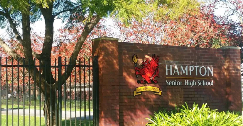 L'insegna in mattoni della Hampton Senior High School davanti ad alberi colorati.