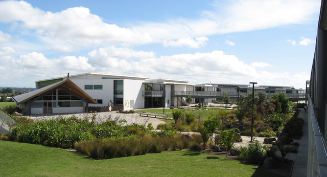 L'Alfriston College mostra un edificio moderno con un'area esterna ben curata e un cielo nuvoloso.