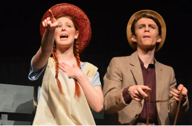 Dos estudiantes de la Sussex Christian School con vestuario actúan durante una obra de teatro en el escenario.