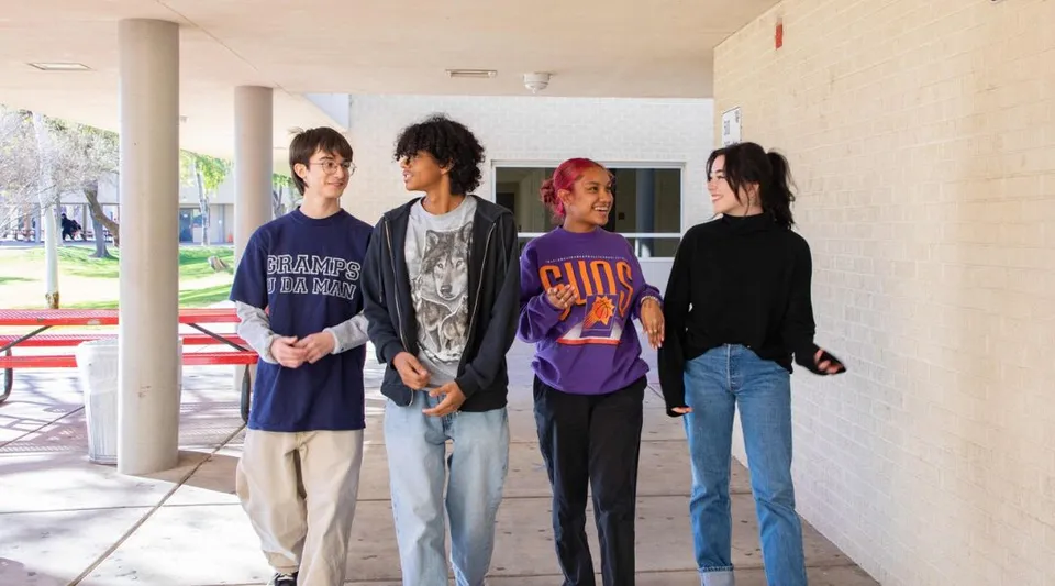 Un gruppo di studenti e studentesse in piedi insieme all'aperto nel campus della Phoenix Union High School.