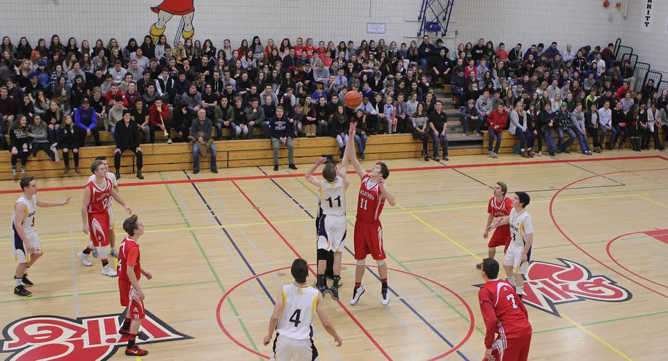 Due giocatori di pallacanestro saltano per la palla a due durante una partita della Valleyview Secondary School.