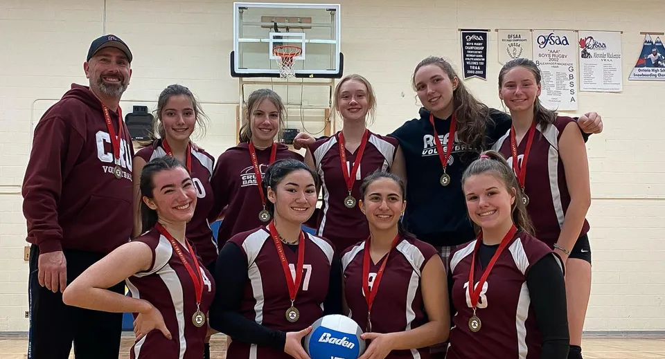 Un gruppo di giovani atlete si trova nella palestra della Alexander Mackenzie High School davanti a un canestro da basket.