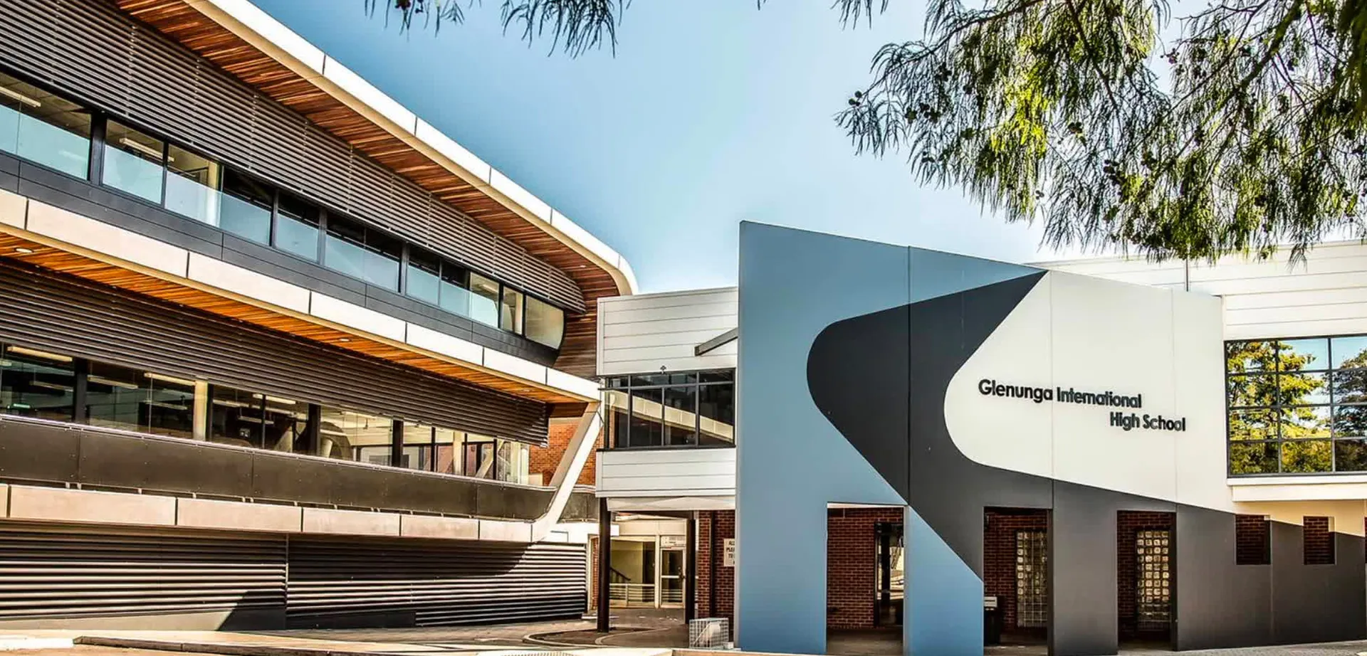 L'edificio scolastico moderno a più piani della Glenunga International High School è circondato da una verde vegetazione.