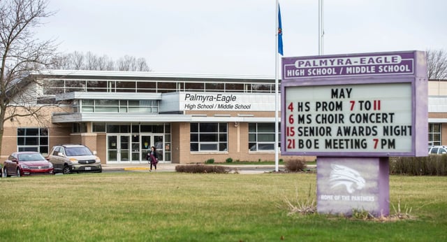 L'edificio scolastico della Eagle School mostra un cartello con gli eventi in programma sul prato circostante.