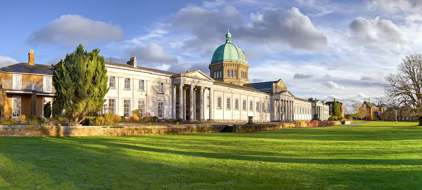 Edificio con cupola e tetto verde nel campus della Haileybury School davanti a un prato verde.