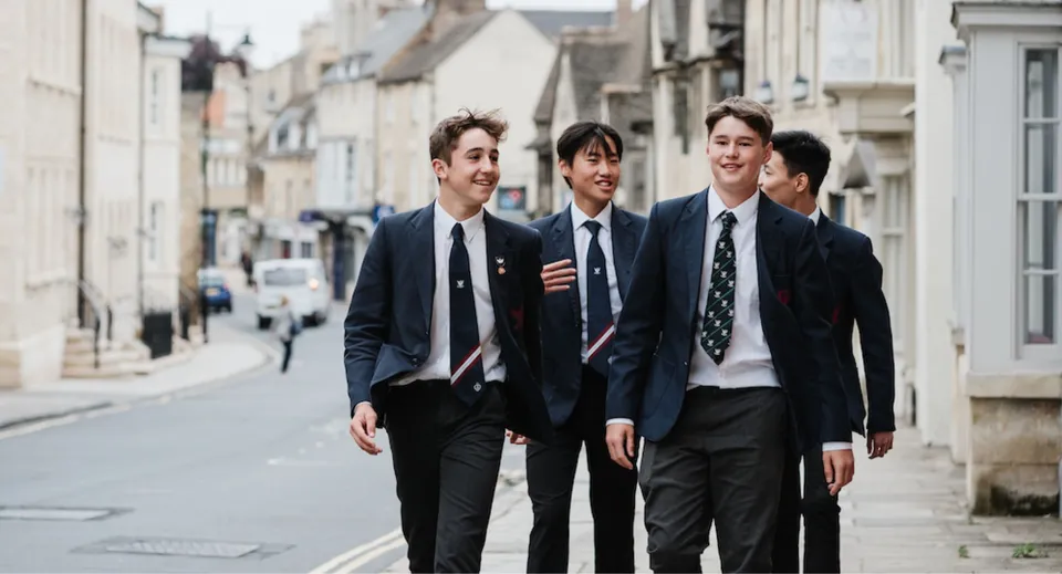 Quattro studenti della Stamford High School camminano in abiti formali lungo una strada della città.
