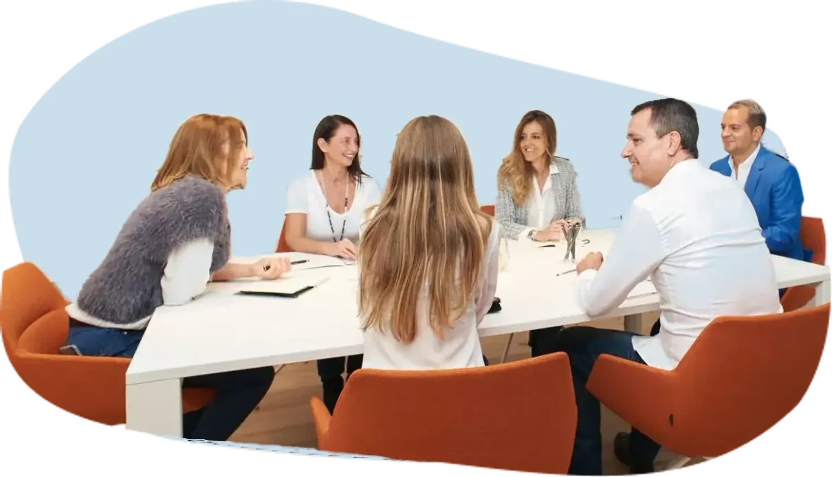Equipo de ICES conversando alrededor de una mesa blanca en la sala de reuniones