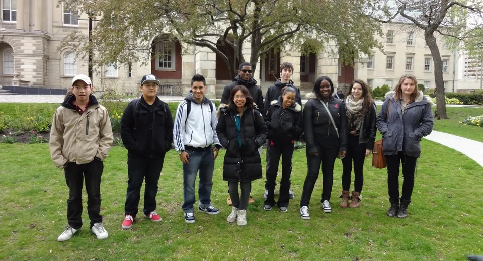 Un gruppo di studenti e studentesse si trova davanti a un edificio storico nel campus della Western Technical-Commercial School.