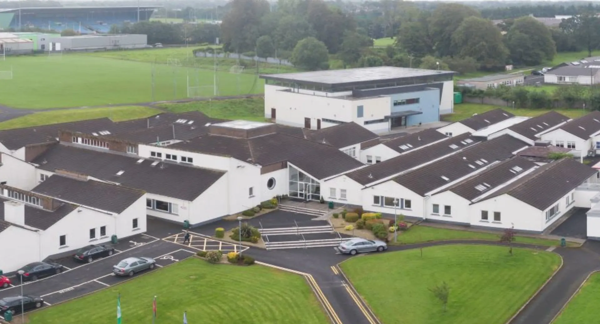 Il campo sportivo e gli edifici circostanti del campus del Davitt College sono immersi in un paesaggio verde.