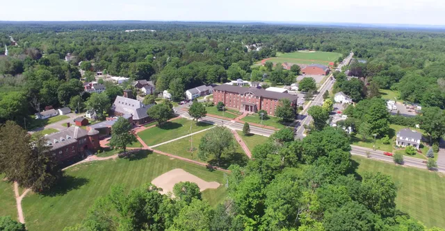 Vista aerea dell'ampio campus della Wilbraham & Monson Academy con edifici storici e moderni immersi nel verde dei boschi.