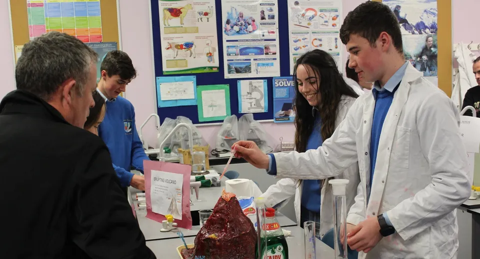 Studenti del Colaiste Chiarain Athlone si radunano in laboratorio attorno a un tavolo con materiale didattico.