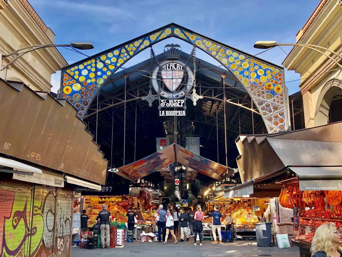 La entrada modernista del Mercat de la Boqueria en Barcelona, con los puestos de fruta al fondo