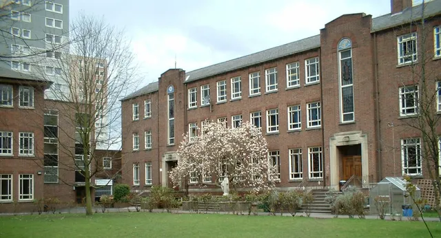 Edificio in mattoni a più piani con albero in fiore e prato nel campus del Loreto College Cavan.
