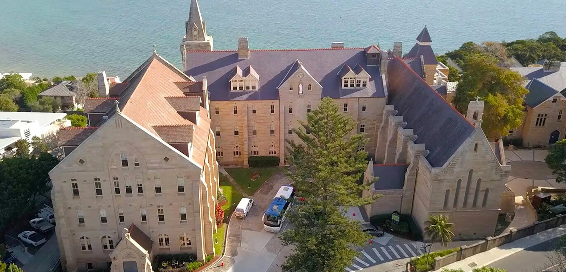 Il castello con architettura medievale nel campus della Kincoppal-Rose Bay è circondato da alberi verdi.