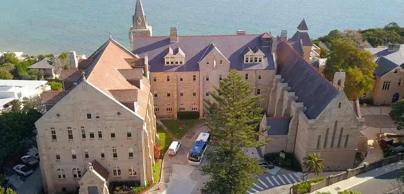 Il castello con architettura medievale nel campus della Kincoppal-Rose Bay è circondato da alberi verdi.