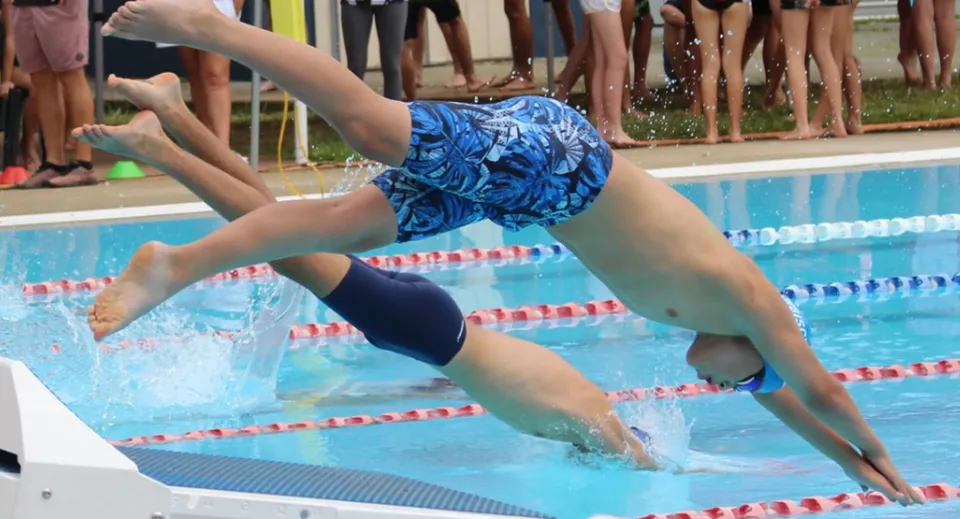 Una studentessa della Mount Gravatt State High School si tuffa in piscina durante la lezione di nuoto.