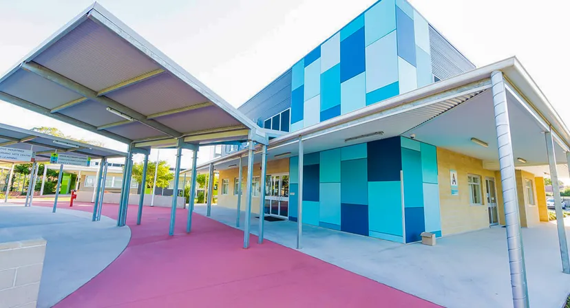 Si vede l'edificio scolastico colorato e moderno con un percorso coperto del Murrumba State Secondary College.