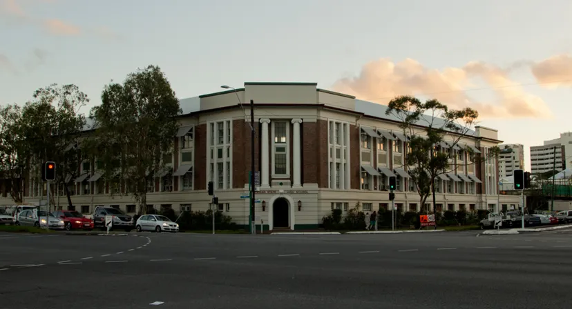 L'imponente edificio principale della Cairns State High School è circondato da palme e aree verdi.