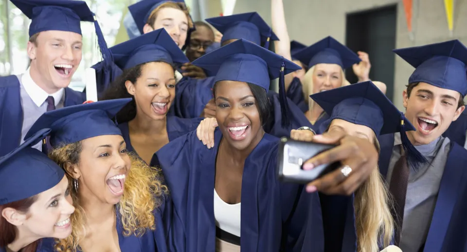 Un gruppo di neodiplomati del Redlynch State College posa insieme in toga blu per una foto di diploma.