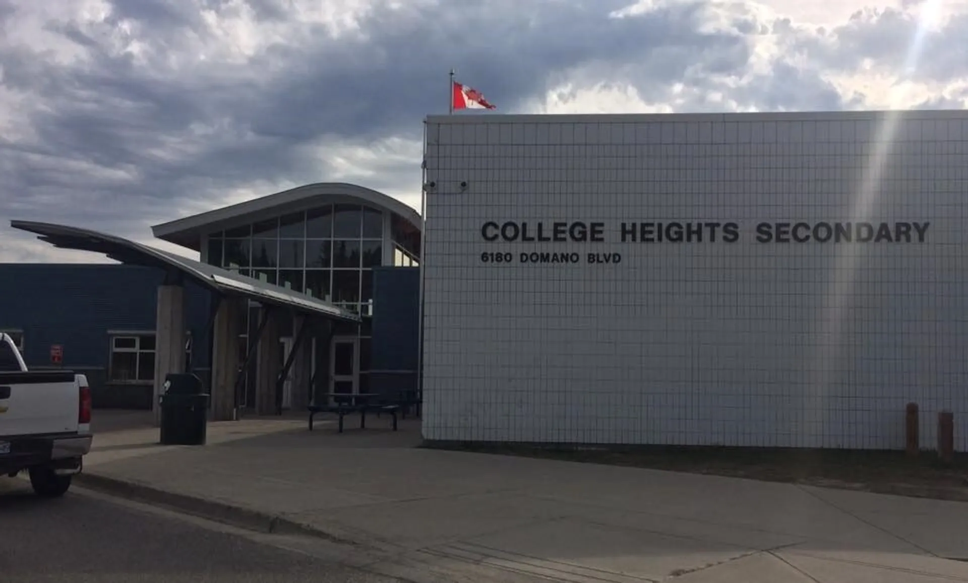 L'edificio scolastico moderno della College Heights Secondary School sotto un cielo nuvoloso.