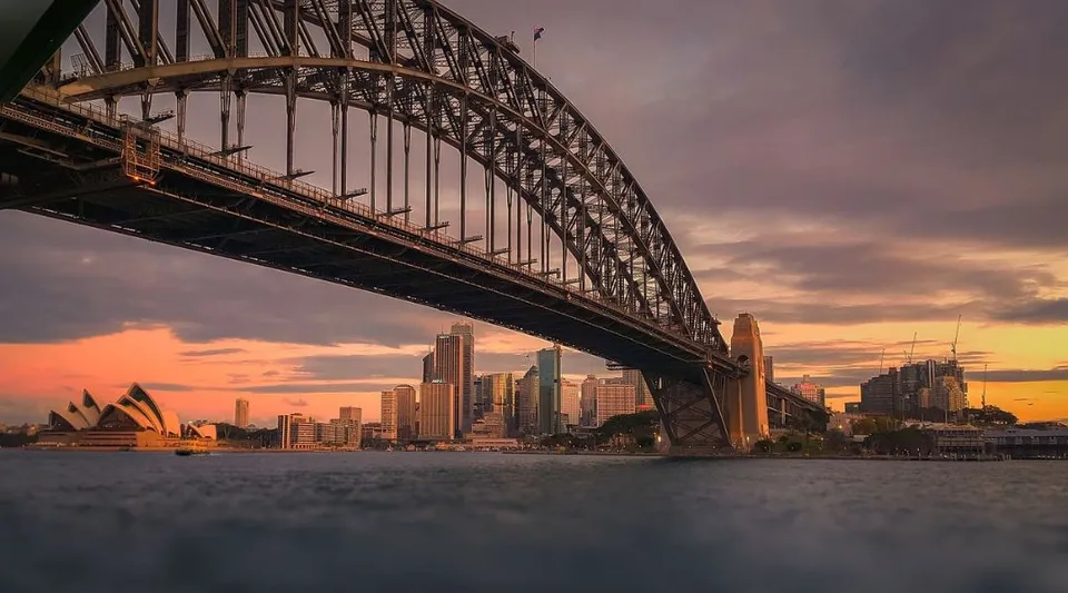 Tramonto sulla Sydney Harbour Bridge con skyline e Opera House sullo sfondo, visto dalla Warners Bay High School.